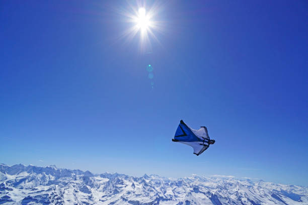 istock Wing suit soars above mountain landscape 1256734541