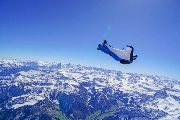 istock Wing suit soars above mountain landscape 1256734669