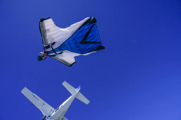 istock Wing suit soars above mountain landscape 1256734687