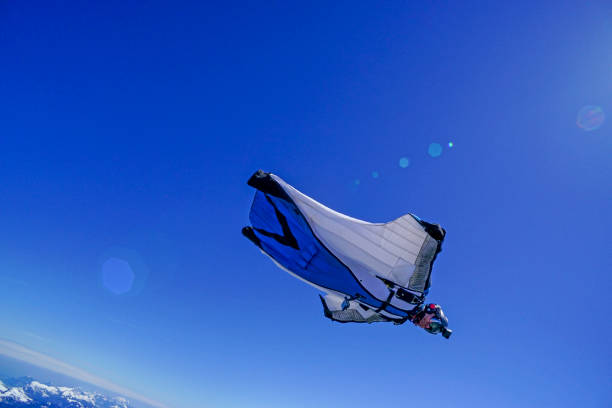 istock Wing suit soars above mountain landscape 1256735079