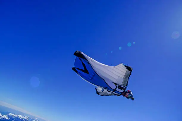 Photo of Wing suit soars above mountain landscape