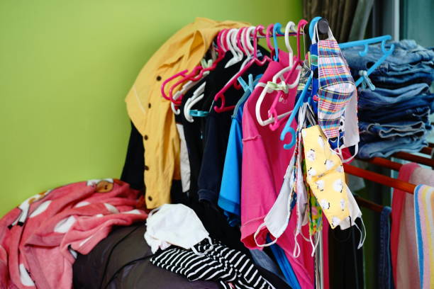 istock Messy clothes scattered on a sofa and Washed laundry is hanging. 1256736390