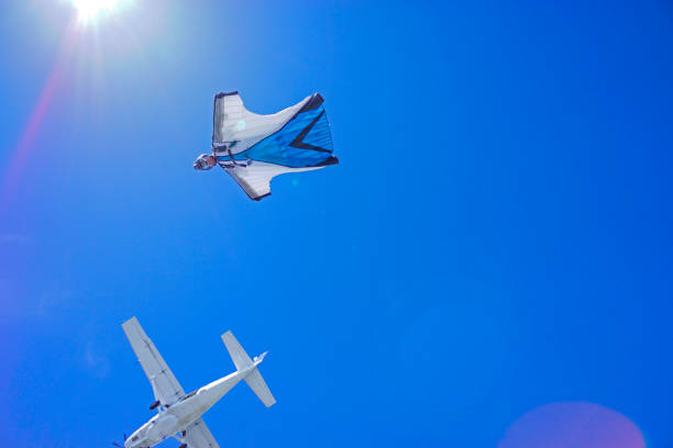 istock Wing suit soars above mountain landscape 1256736505