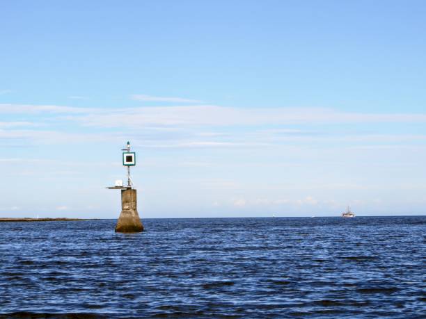 View of a port hand day beacon marking a reef hidden by the ocean at high tide. The Port Hand Day Beacon marks the port (left) side of a channel or the location of a danger during daylight hours vista de una baliza de día de la mano del puerto que marca un arrecife escondido por el océano en marea alta. el port hand day beacon marca el puerto (izquierda) del lado de un canal o la ubicación de un peligro durante las horas de luz del día