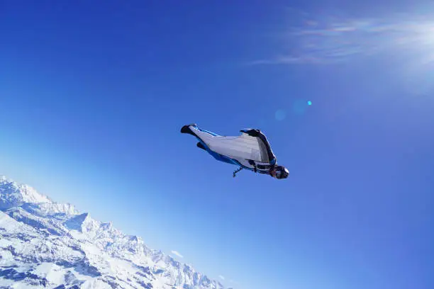 Photo of Wing suit soars above mountain landscape