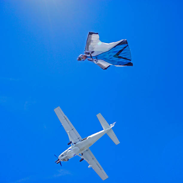 istock Wing suit soars above mountain landscape 1256737027