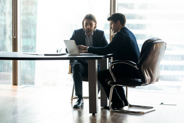 istock Motivated young employee discussing computer presentation with boss. 1256739907