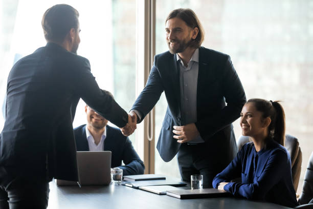 istock Smiling hr team leader shaking hands with job seeker. 1256739955