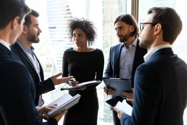 istock Focused young diverse business people discussing project ideas in circle. 1256739967