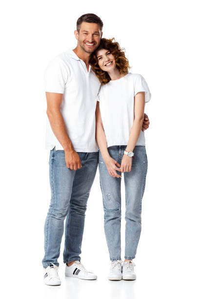 homme heureux souriant tout en étreignant la femme gaie sur le blanc - t shirt white men jeans photos et images de collection