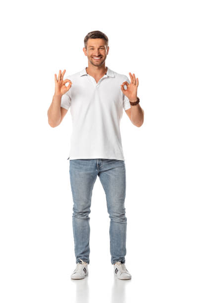 istock cheerful man showing ok sign and standing on white 1256740010