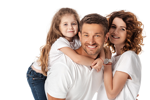 happy kid hugging father near cheerful mother isolated on white