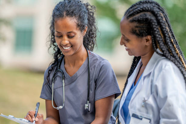istock Two African American medical professionals having a discussion while sitting on a bench 1256740759