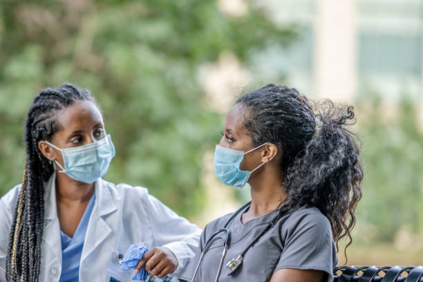 istock Two African American medical professionals sitting on a bench 1256740771