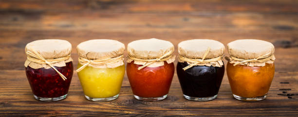 various homemade fruit jam in the jars - raspberry table wood autumn imagens e fotografias de stock