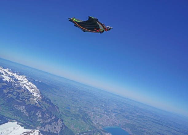istock Wingsuit flier soars above mountain landscape 1256744658