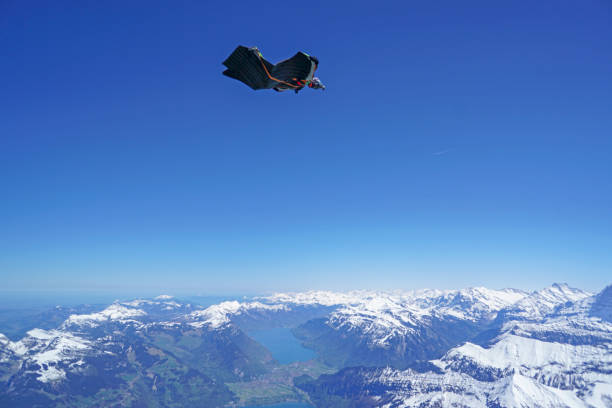 istock Wingsuit flier soars above mountain landscape 1256744740