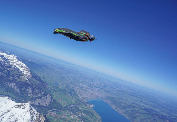 istock Wingsuit flier soars above mountain landscape 1256745002
