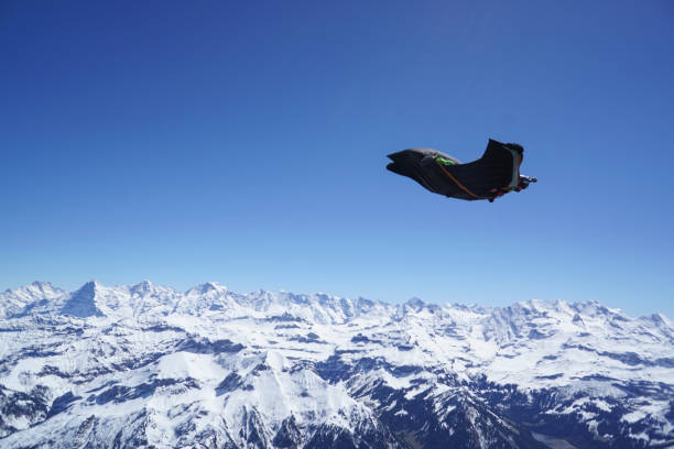 istock Wingsuit flier soars above mountain landscape 1256745097