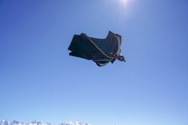 istock Wingsuit flier soars above mountain landscape 1256745228