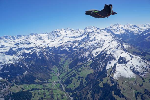 istock Wingsuit flier soars above mountain landscape 1256745907