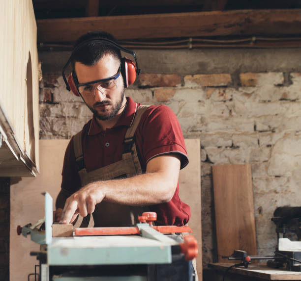 istock Woodworker Cutting Wood in his Workshop 1256745940
