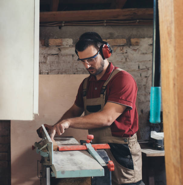 istock Woodworker Cutting Wood in his Workshop 1256745951