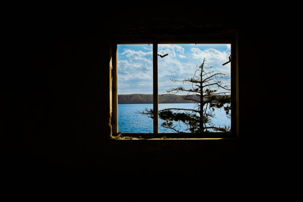 Window of a Dark Room with a view on the Seaside
