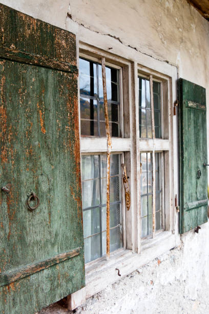 200 years old window with lead glazing and shutters window on a farmhouse.