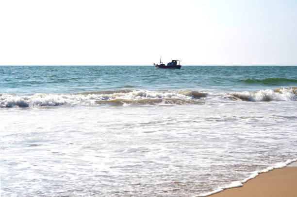 istock Fishing boat on the horizon at the Beach 1256750357