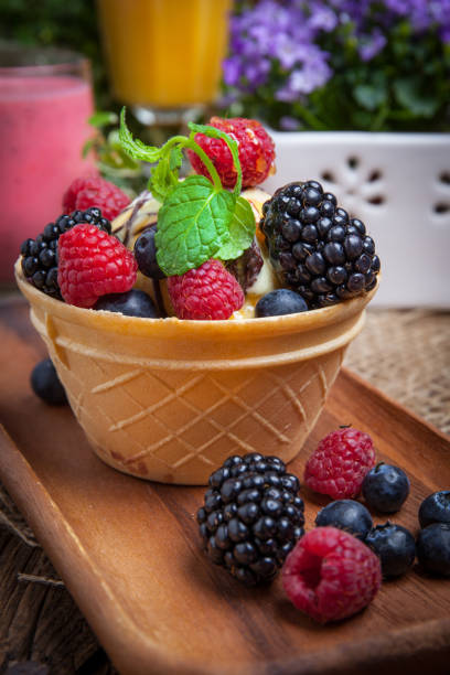 istock Tasty ice cream dessert with fruit in a waffle bowl. 1256752179