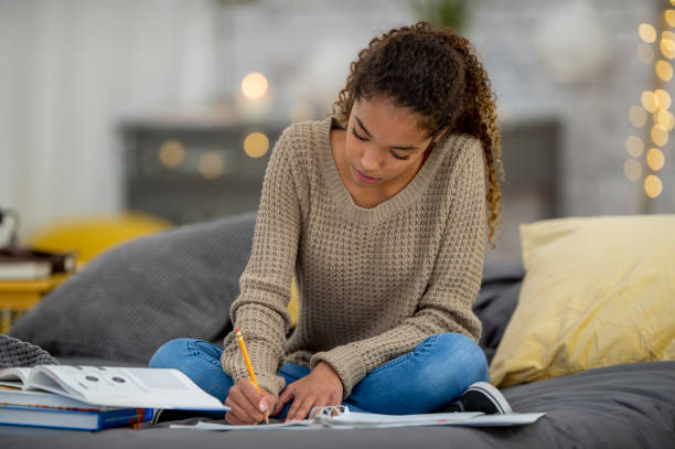 istock Teenage girl does school work from home 1256756613