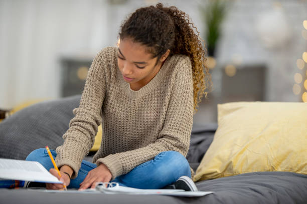 istock Teenage girl does school work from home 1256756618