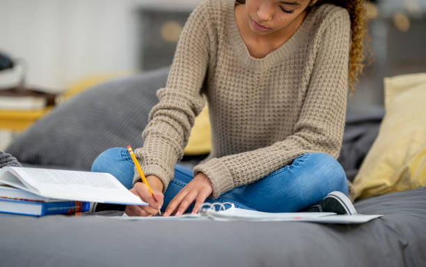 istock Teenage girl does school work from home 1256756621
