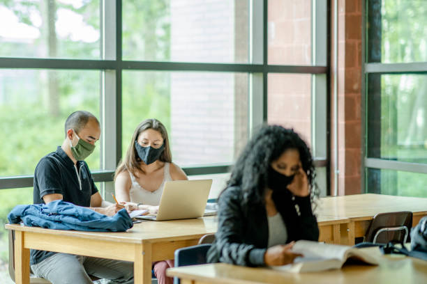 istock Small group of mixed ethnicity students wearing masks in a classroom 1256757836