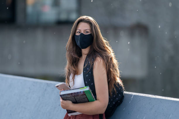 istock Beautiful female university student on campus with a mask on 1256757879
