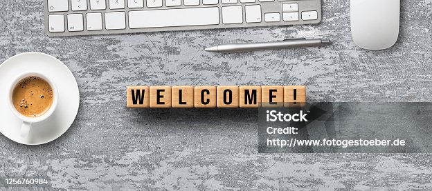istock cubes with message WELCOME and office items 1256760984