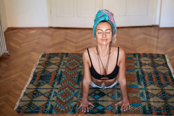 istock Front view of a young woman practicing yoga at home 1256761141