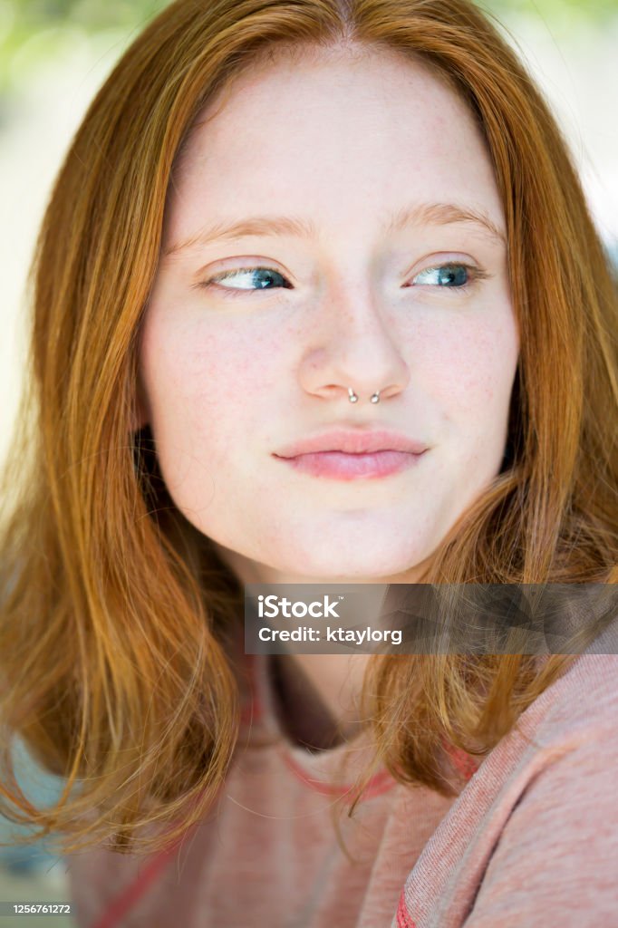 Closeup of redheaded teen with nose ring Natural beauty of female young adult looking away from camera Light Skin Tone Stock Photo