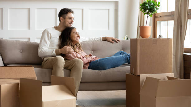 istock Happy young couple relaxing on couch on moving day 1256762244