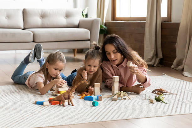 istock Young mother playing with two daughters on warm floor 1256762257