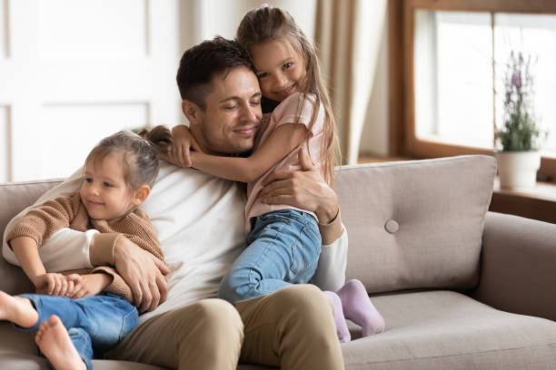 istock Loving young father cuddling with two little daughters 1256762264