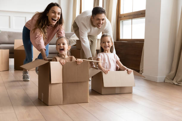 istock Happy parents playing with daughters in new apartment 1256762265