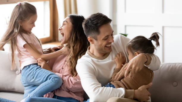istock Excited parents having fun with two little daughters at home 1256762273