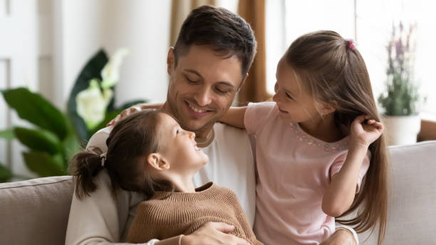 istock Happy loving young father hugging two little daughters 1256762278