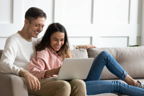 istock Happy young couple using laptop together, having fun on weekend 1256762283