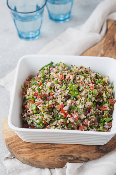 quinoa quinua salat mit tomaten und kräutern in weißer schüssel - tabbouleh vegeterian food middle stock-fotos und bilder