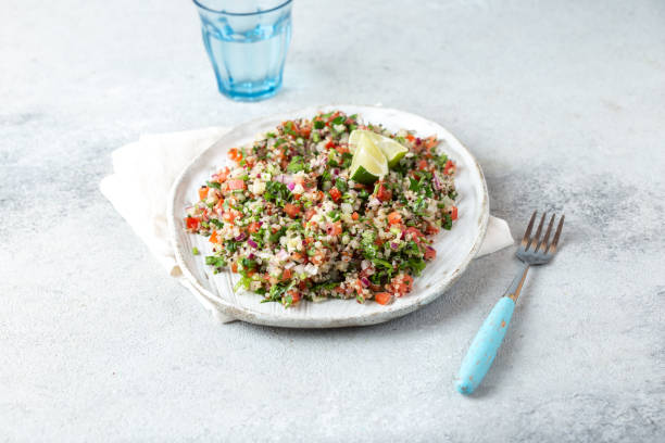 quinoa quinua salat mit tomaten und kräutern in weißer schüssel - tabbouleh vegeterian food middle stock-fotos und bilder