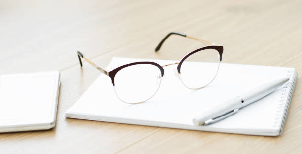 istock Close-up of glasses with a notebook on the table. Working space 1256764407