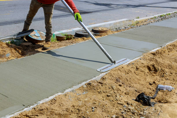 istock Laying down a new sidewalk in wet concrete on freshly poured sidewalks 1256767949